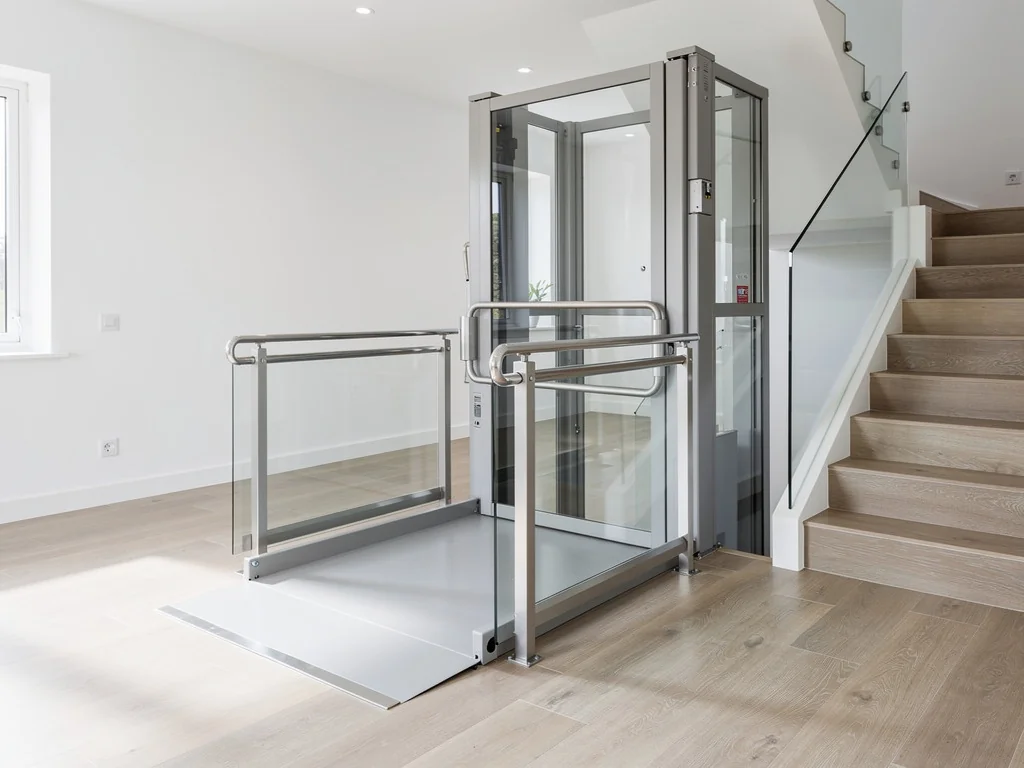 Plateforme élévatrice vitrée installée près d'un escalier pour fauteuil roulant